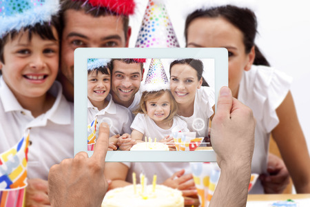 Composite image of hand holding tablet pc showing photograph
