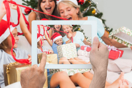 Composite image of hand holding tablet pc showing photograph
