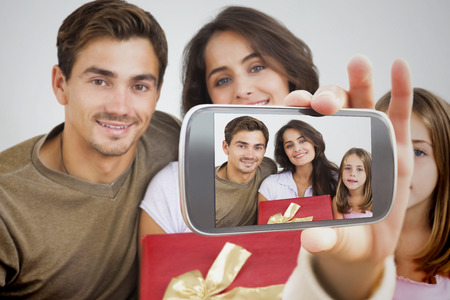 Composite image of hand holding smartphone showing photographの写真素材