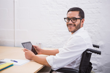 Portrait of young businessman using digital tablet at office deskの写真素材
