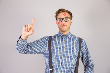 Geeky hipster covered in kisses on grey backgroundの写真素材