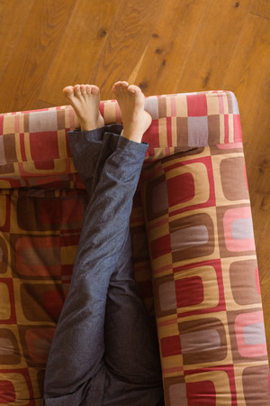 Mans legs on the couch at home in the living roomの写真素材