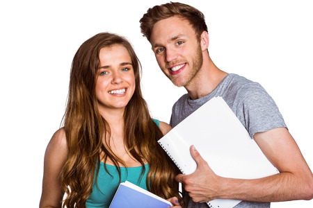 Portrait of smiling young couple with books over white backgroundの写真素材