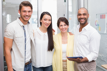 Smiling business colleagues with digital tablet in the office