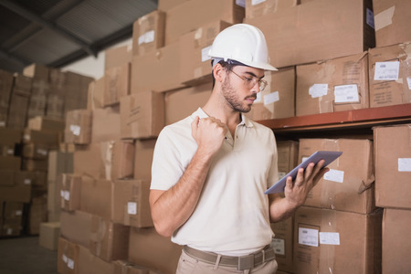 Warehouse worker using digital tablet in warehouse