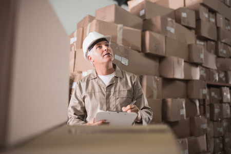 Warehouse worker with clipboard in warehouseの写真素材