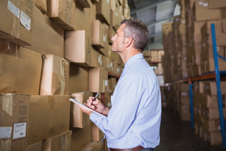 Side view of manager holding clipboard in the warehouseの写真素材