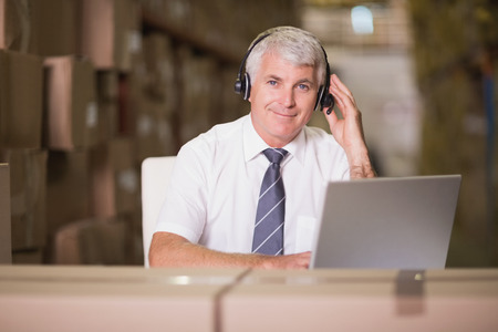 Portrait of warehouse manager using laptop at warehouseの写真素材