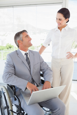 Disabled business man working with partner in the officeの写真素材