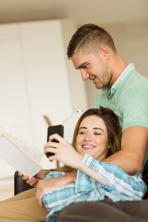 Cute couple relaxing on couch at home in the living roomの写真素材