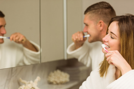 Cute couple brushing their teeth at home in the bathroomの写真素材