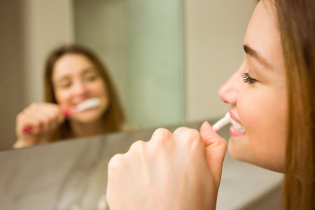 Cute couple brushing their teeth at home in the bathroomの写真素材