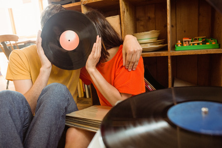 Young couple listening to vinyl record at home in the living room