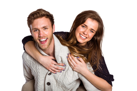 Portrait of smiling young man carrying woman over white backgroundの写真素材