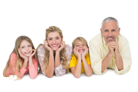 Happy family lying and smiling on white backgroundの写真素材