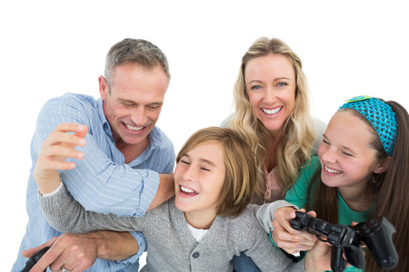 Happy family with two children playing video games on white backgroundの写真素材
