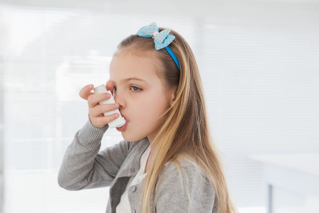Small girl using her inhaler at a hospitalの写真素材