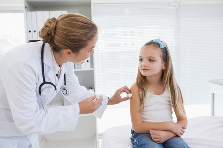 Doctor giving a patient an injection at workの写真素材