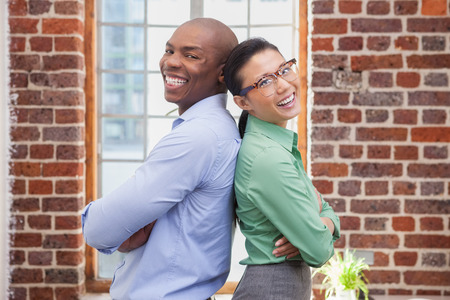Casual business people smiling at camera in the officeの写真素材