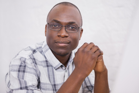 Man wearing glasses smiling at camera in the office
