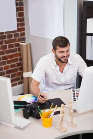 Smiling designer working on his computer in the officeの写真素材