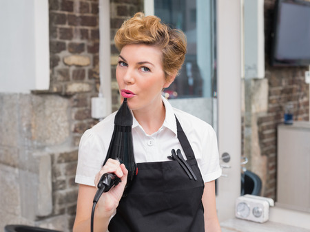Confident hairdresser smiling at camera at the hair salonの写真素材