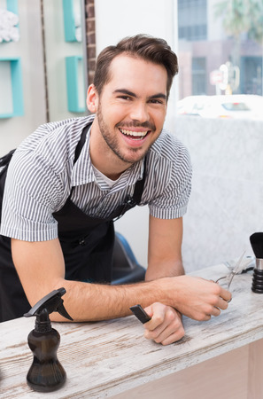 Handsome hair stylist smiling at camera at the hair salonの写真素材