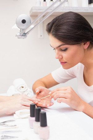 Nail technician giving customer a manicure at the beauty salonの写真素材