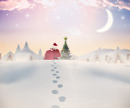 Santa walking in the snow against cute christmas village with treeの写真素材