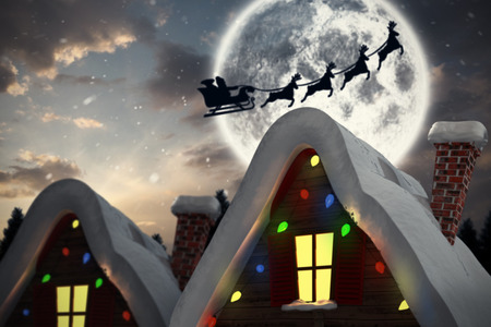 Silhouette of santa claus and reindeer against cute christmas villageの写真素材