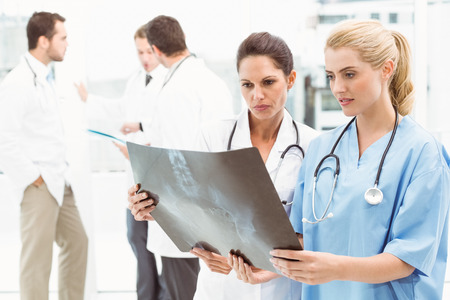 Two female doctors examining x-ray in the medical office