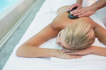 High angle view of a beautiful young woman receiving stone massage at health farmの写真素材