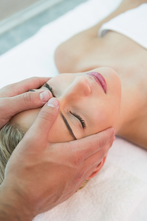High angle view of an attractive young woman receiving head massage at spa centerの写真素材