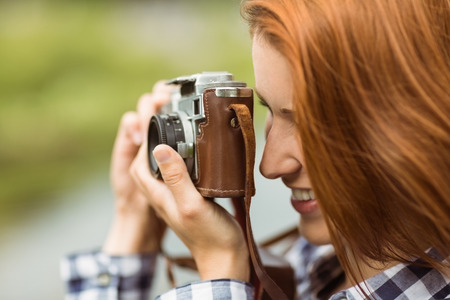 Redhead woman taking a photo in a parkの写真素材