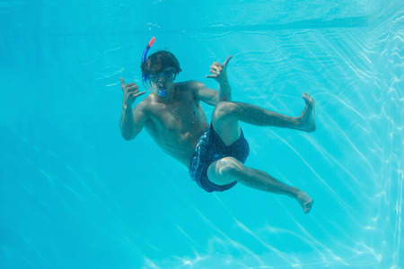 Full length of a young man wearing snorkel underwater
