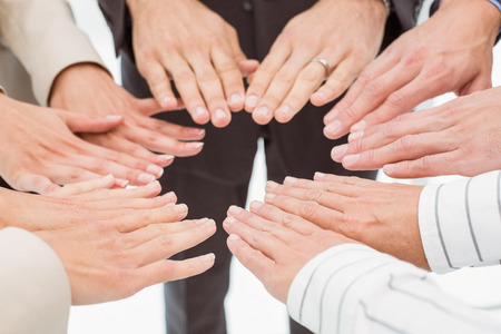 Close up of executives holding hands together in the officeの写真素材