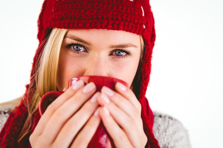 Festive blonde holding a mug on white backgroundの写真素材