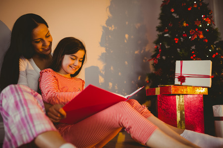 Mother and daughter waiting for santa claus at home in the living roomの写真素材
