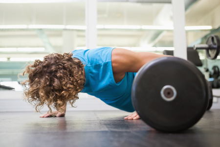 Side view of a young man doing push ups in the gymの写真素材