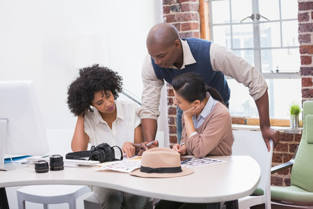 Concentrated casual photo editors at work in the officeの写真素材