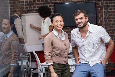 Portrait of two confident young business people standing in office