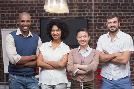 Portrait of confident young business people with arms crossed in office