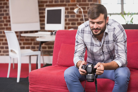 Concentrated casual photo editor looking at camera in the officeの写真素材