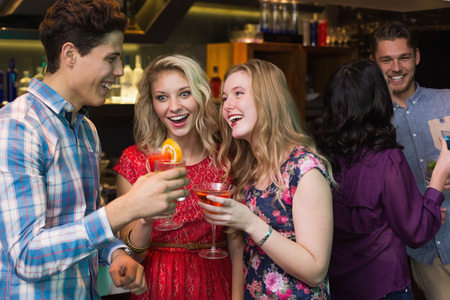 Happy friends having a drink together at the barの写真素材