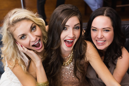 Happy friends making silly faces at the barの写真素材