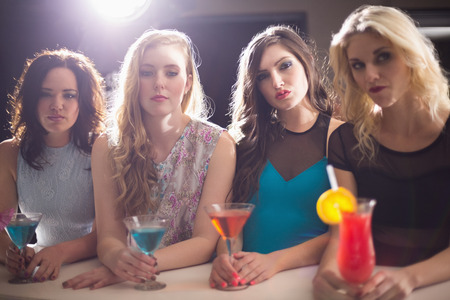 Attractive friends drinking cocktails together at the barの写真素材