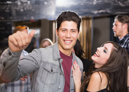 Stylish couple smiling and dancing together at the bar