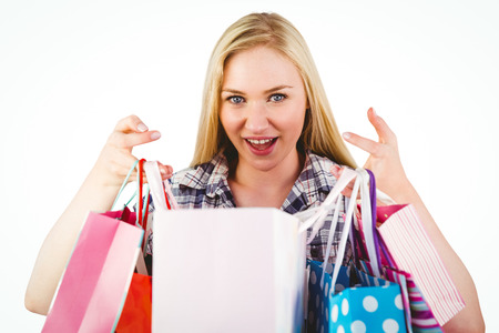 Pretty young blonde holding shopping bags on white backgroundの写真素材