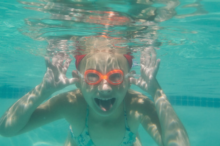Cute kid posing underwater in pool at the leisure centerの写真素材