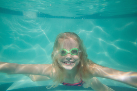 Cute kid posing underwater in pool at the leisure centerの写真素材